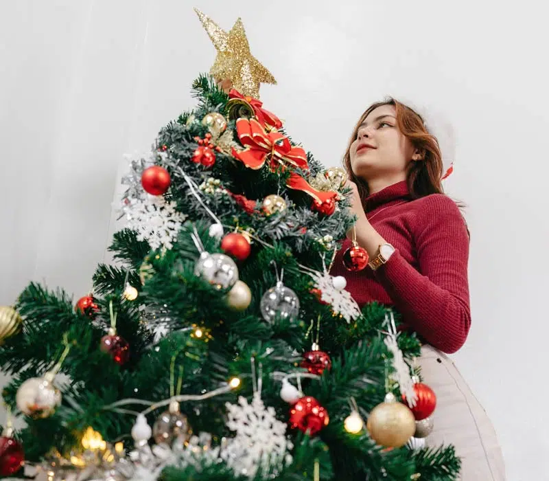 Femme décore son sapin de Noël