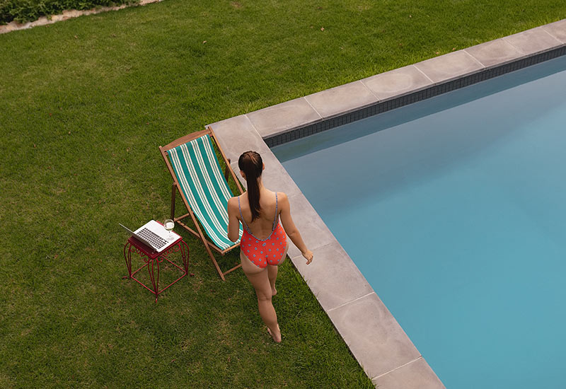 Femme au bord de sa piscine.